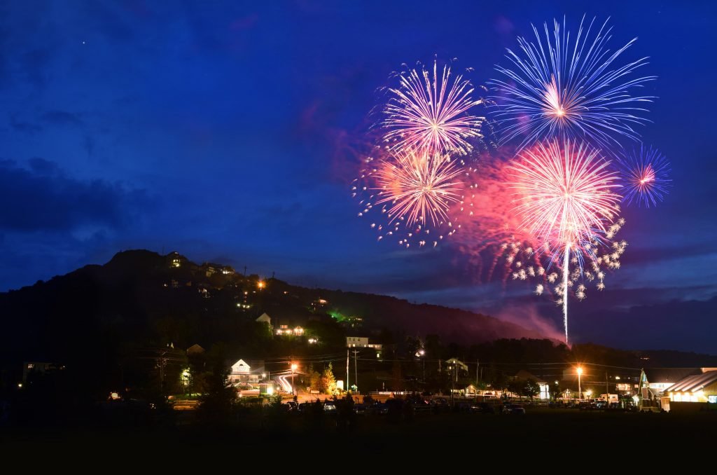Colorful fireworks lighting up the sky over the mountain.