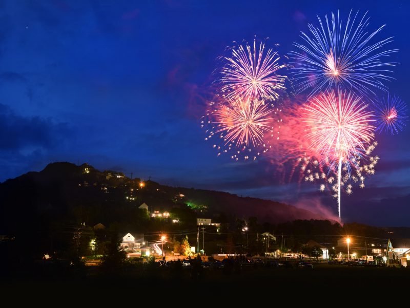 Colorful fireworks lighting up the sky over the mountain.