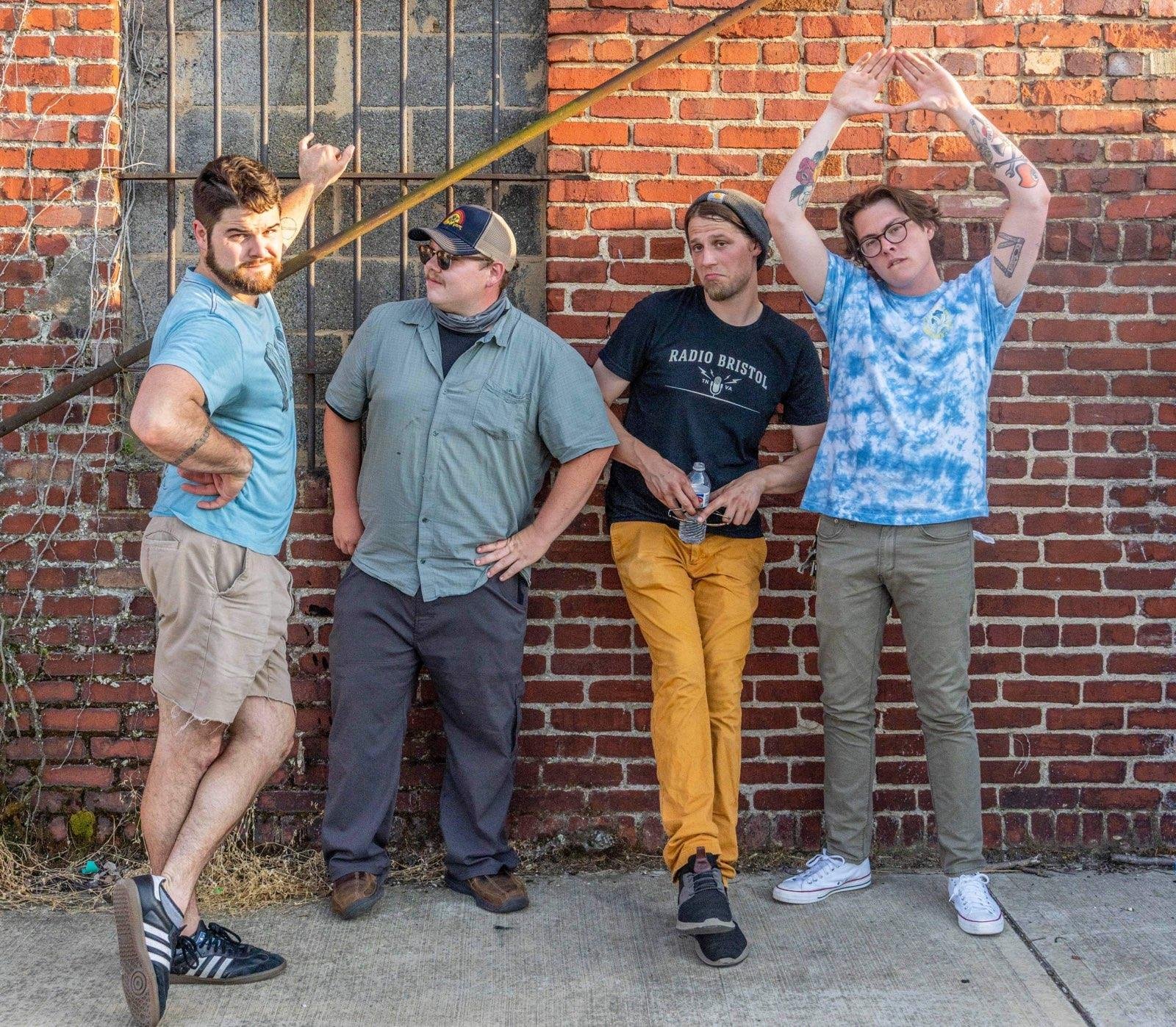 Donnie and the dry heavers pose in front of a brick wall