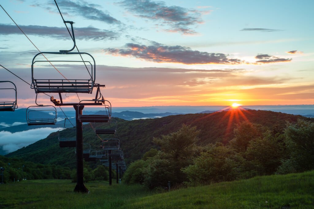 A picturesque sunset setting at 5,506 feet, Beech Mountain Resort's outdoor dining experience offers delectable meals amidst stunning mountain vistas.