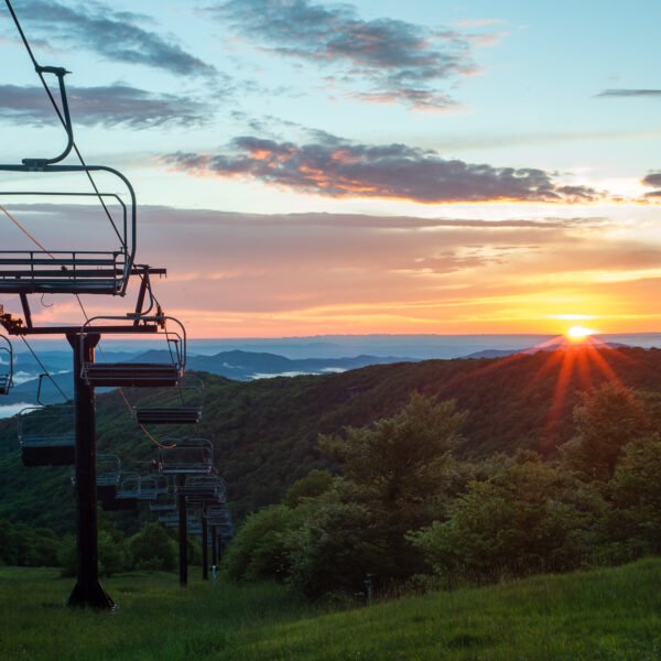 A picturesque sunset setting at 5,506 feet, Beech Mountain Resort's outdoor dining experience offers delectable meals amidst stunning mountain vistas.