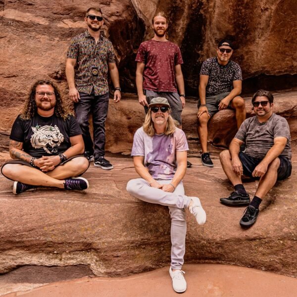 The band, The Hip Abduction, all 6 men, sitting on western looking red rocks
