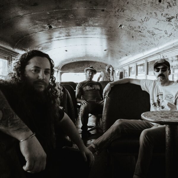 four band members sitting in a bus